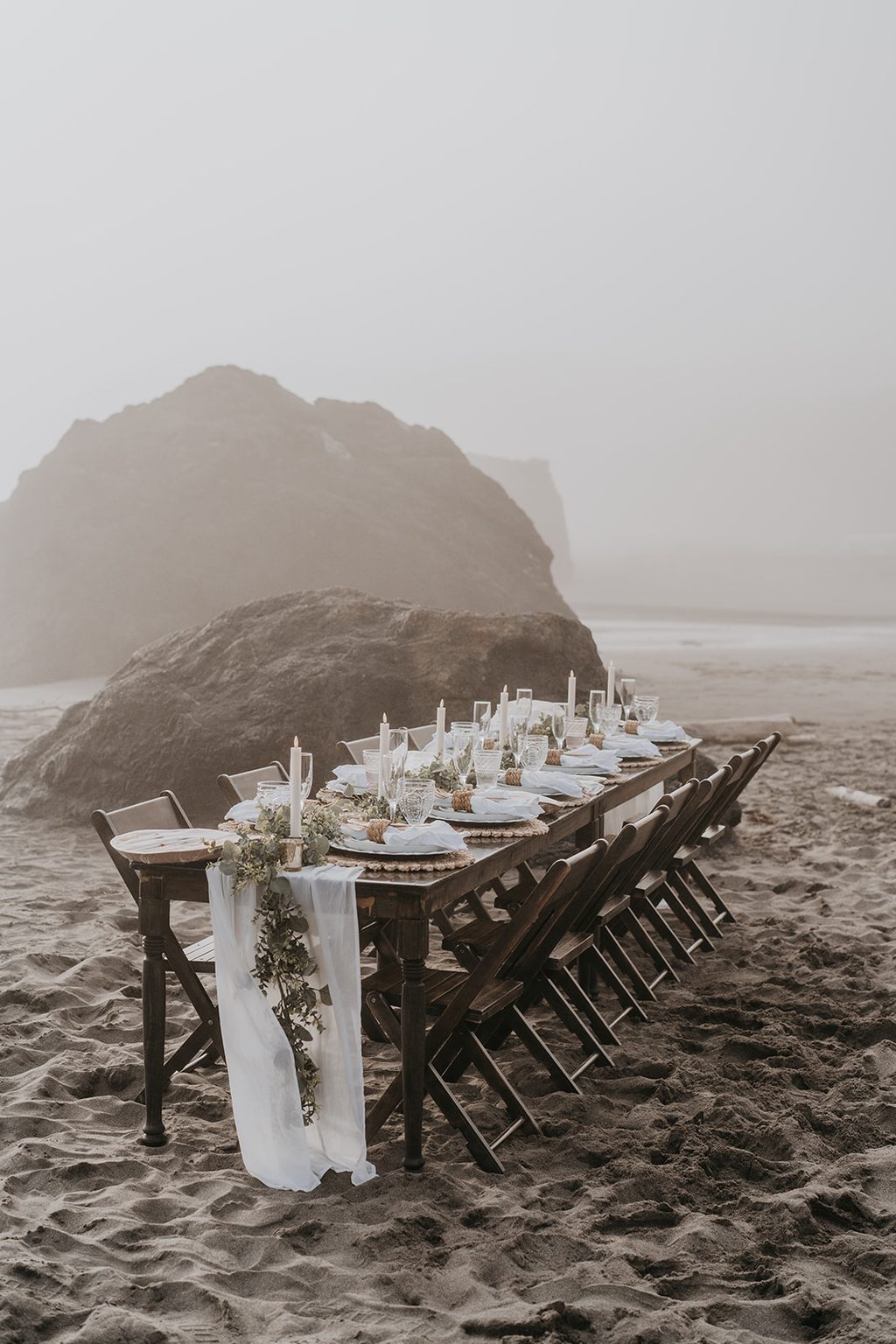 Long banquet table set on a foggy Oregon beach.